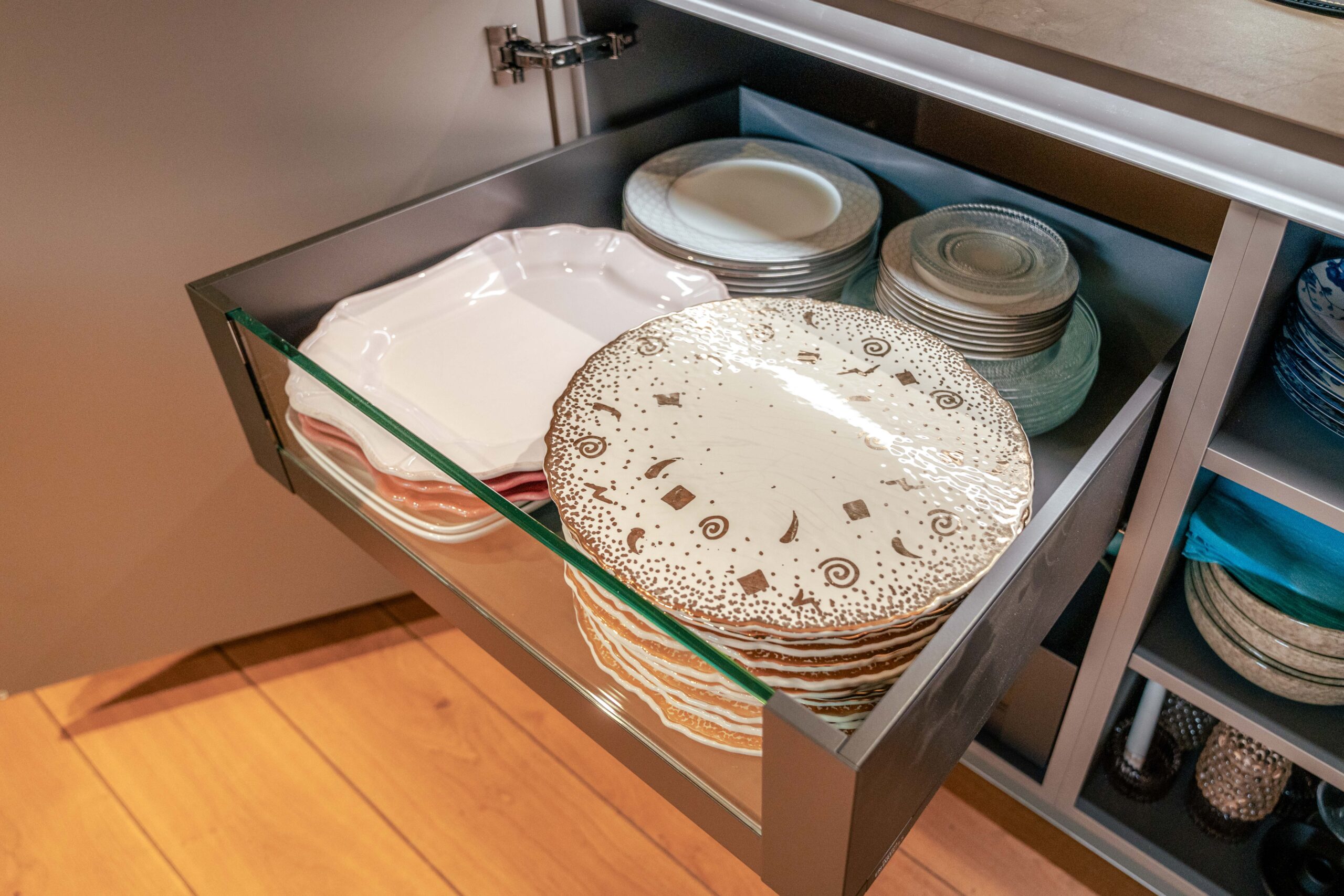 Rangement coulissant pour vaisselle intégré dans une cuisine sur mesure Erhart & Fils